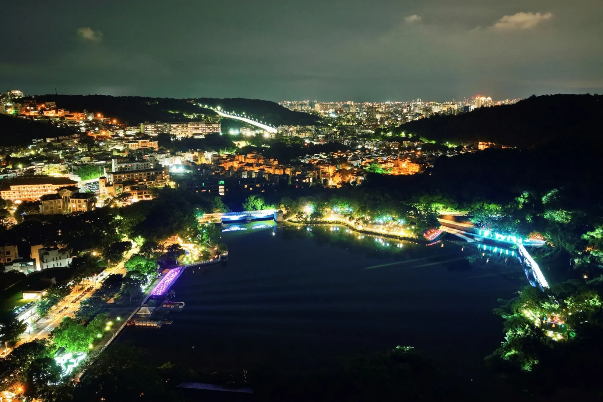青草湖光環境藝術夜間空拍全景,湖岸燈光與新竹城市夜景相連