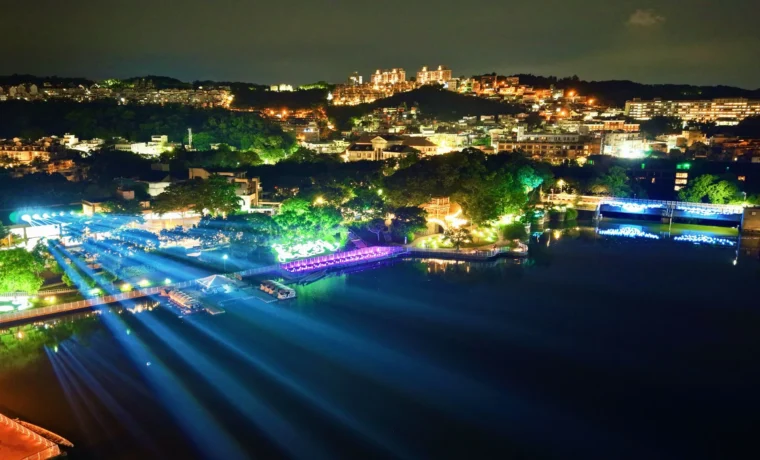 青草湖空拍夜景，藍色展演光束橫越湖面並串聯水岸燈飾