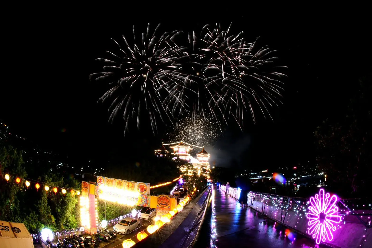 鷄籠中元祭會場銀白煙火照亮祭典建築與夜間燈飾步道