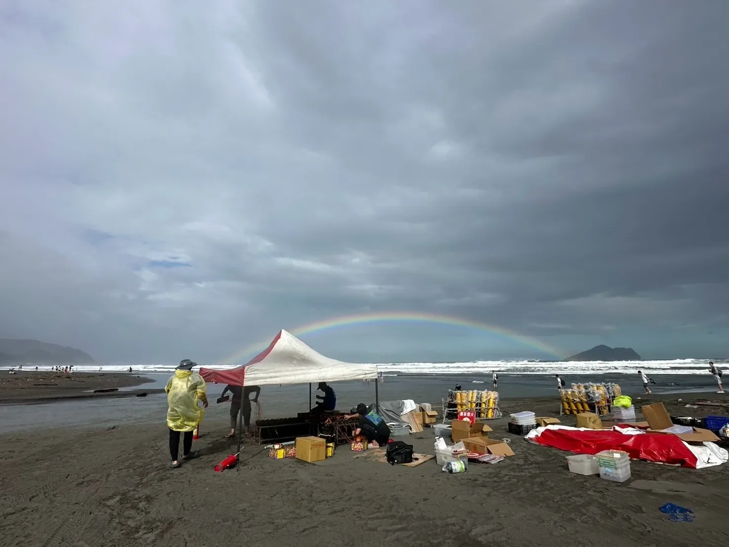 外澳沙灘煙火設置現場,帳篷旁整備發射設備且海面上方出現彩虹