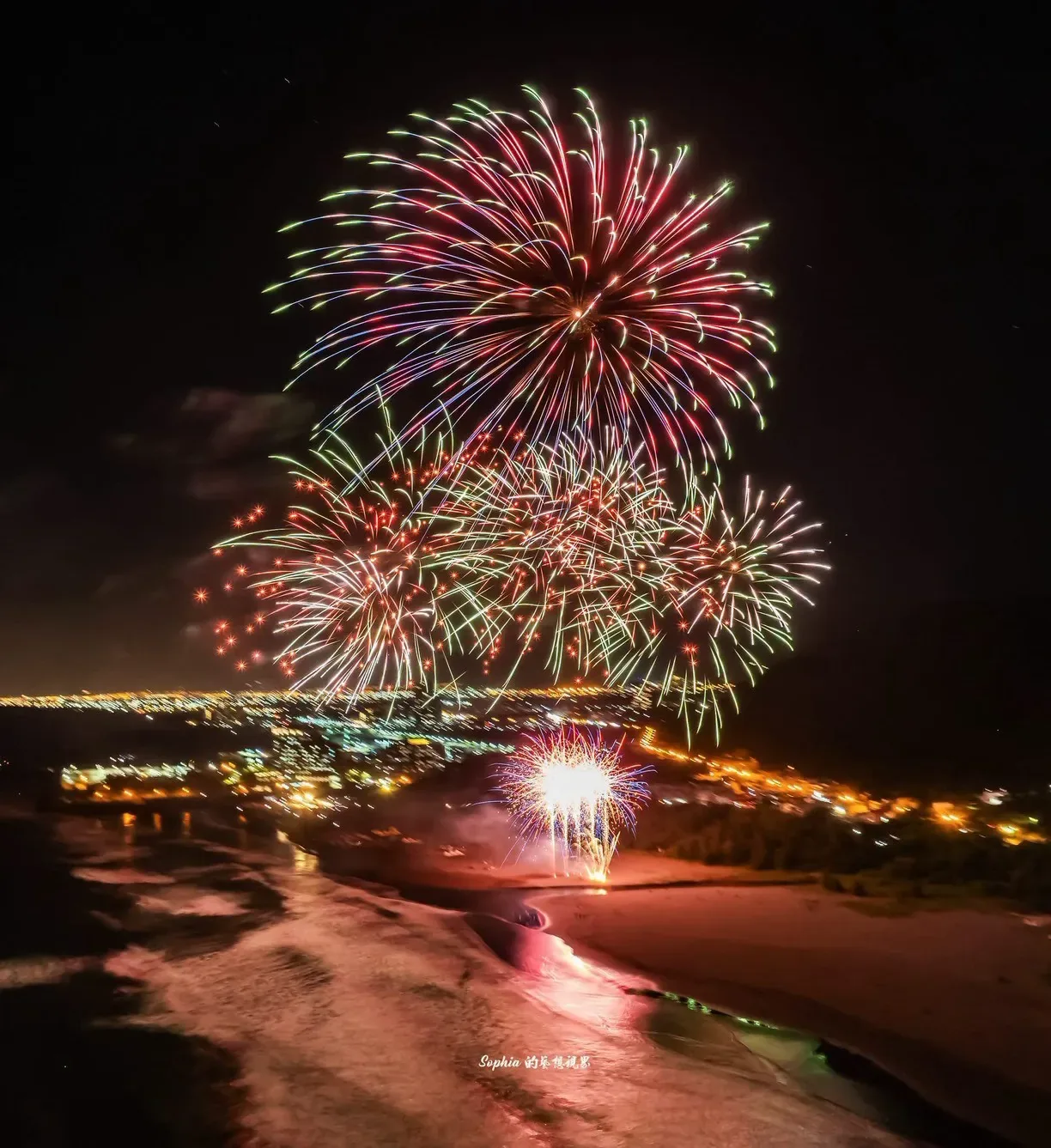 宜蘭外澳罟浪祭高空煙火,紅綠花火與近岸低空效果映照潮水