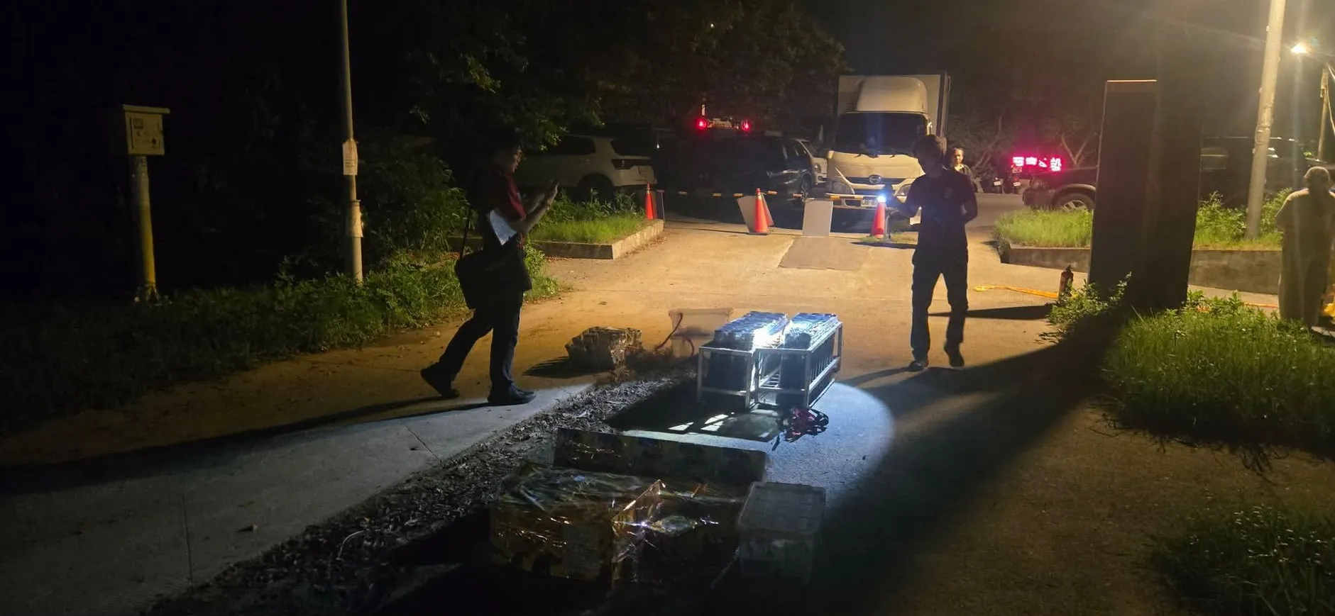 工作人員於虎仔山夜間搬運煙火設備箱至施放區